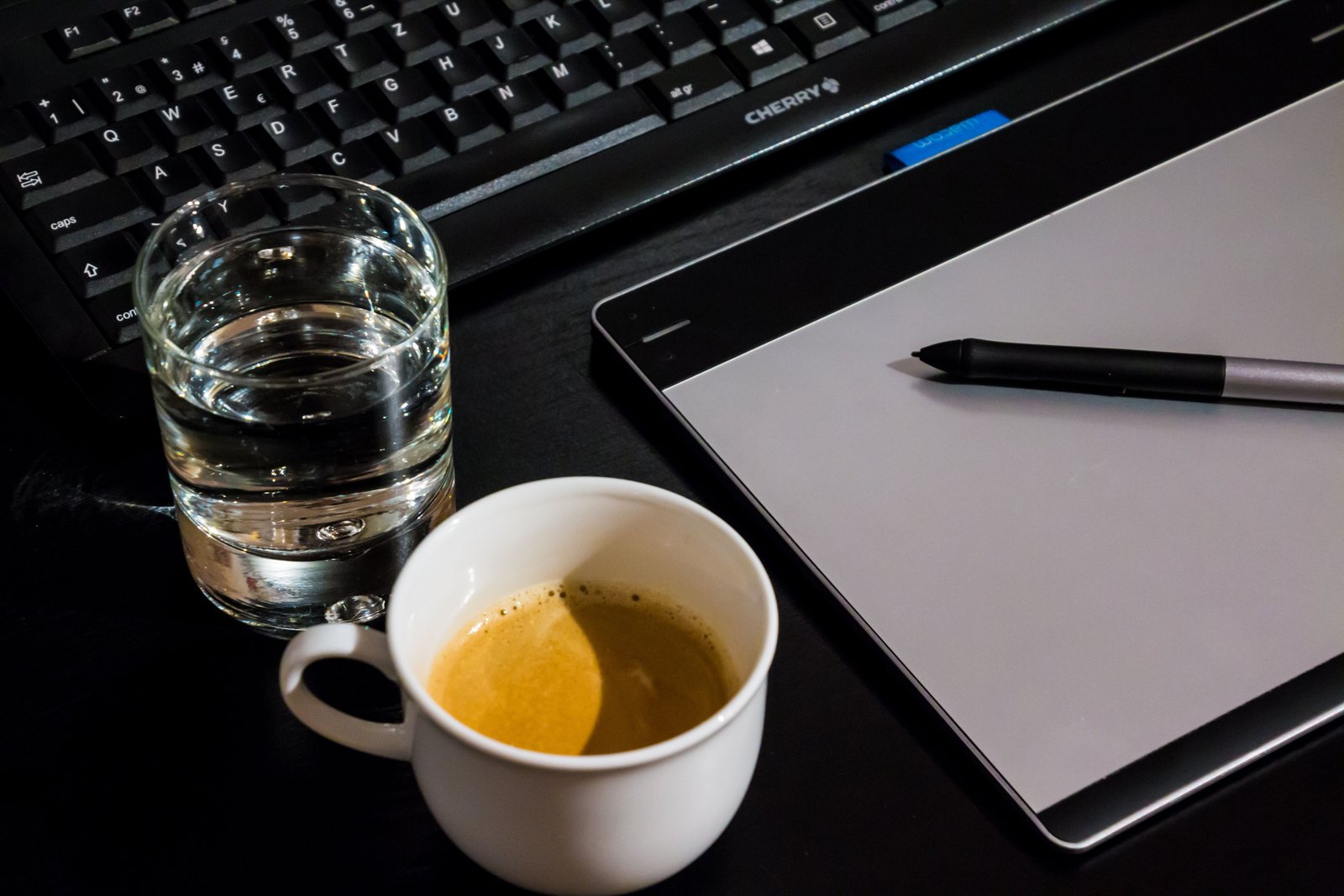 Coffee and water on the table next to tablet.